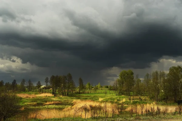 Thunderstorm weather in spring. countryside, meadows and trees.