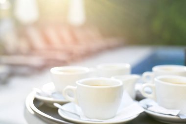 Bilardo masasında beyaz kahve fincanları. Yumuşak odaklı çok parlak bir yaz fotoğrafı..