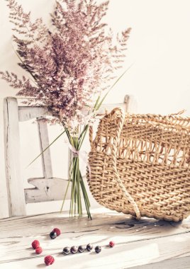 Vintage yaz natürmortu. Eski beyaz bir sandalyede yürüyen bir çanta ve kuru ot kulakları. basit vintage öğeleri.