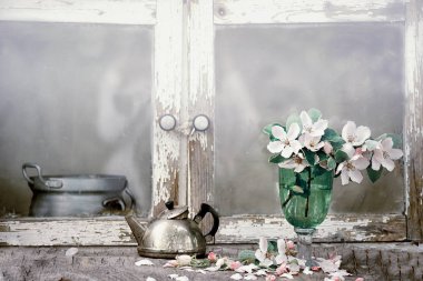 Bahçede eski bir çatlak büfe üzerinde cam kadeh bir elma ağacının narin çiçekleri. Vintage fotoğraf. Seçici odaklama.