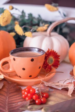 Bir buharlı içecek ve viburnum sonbahar kırmızı meyveleri ile bir fincan. Sonbahar rahat ev natürmort.