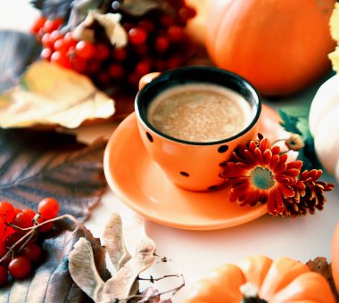 Bir buharlı içecek ve viburnum sonbahar kırmızı meyveleri ile bir fincan. Sonbahar rahat ev natürmort.