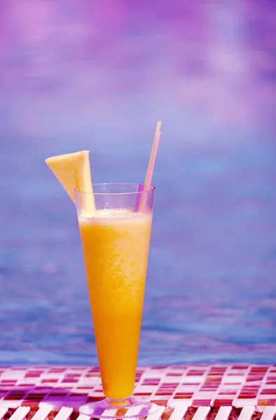 Freshly squeezed fruit pineapple orange juice on a background of the sea.