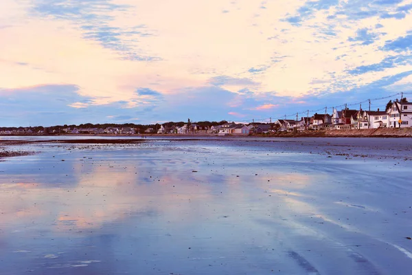 Early  morning on the Atlantic coast. Life of a small town on the coast of the Atlantic Ocean. Reflection of the dawn sky in the water on the sand. USA. Maine.