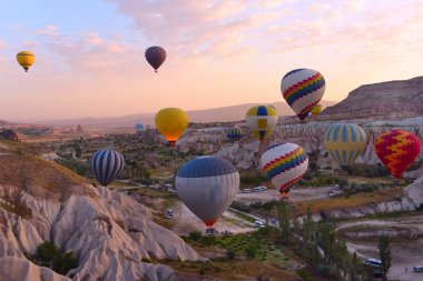 Renkli hava balonları güzel bir kayalık manzara arasında gün doğumunda gökyüzüne kadar sinek. Kapadokya Türkiye.