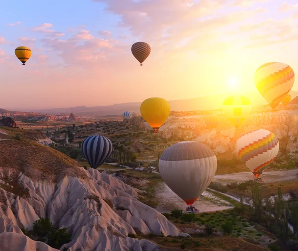 カラフルな気球は 美しい岩の風景の中で日の出時に空に飛びます カッパドキア トルコ — ストック写真