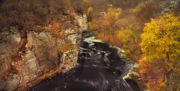 A river flowing in a stone canyon among yellow trees. Autumn landscape, view from above.