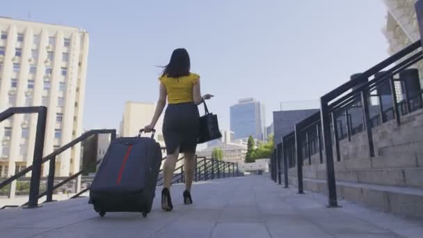 Low angle of business woman with luggage walking — Stock Video