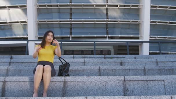 Csalódott ázsiai üzleti nő ül a lépcsőn — Stock videók