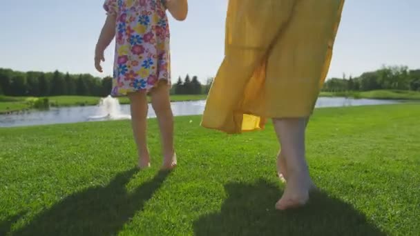 Nohy, Maminka a dcera, chůze po trávě naboso — Stock video