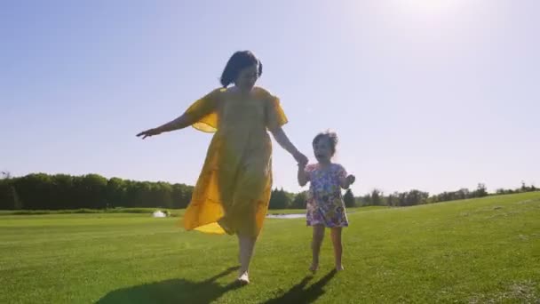 Maman et fille courir ensemble sur prairie — Video