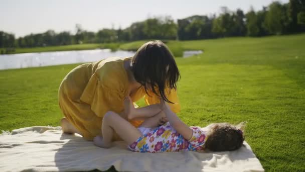 Mutter bringt kleine Tochter im Park zum Lachen