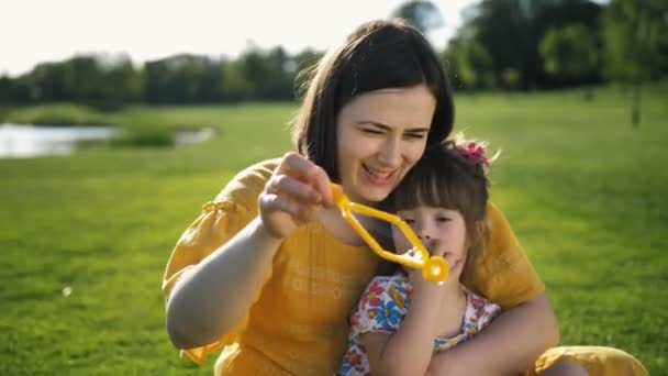 Mutter pustet Seifenblasen mit besonderer Tochter — Stockvideo