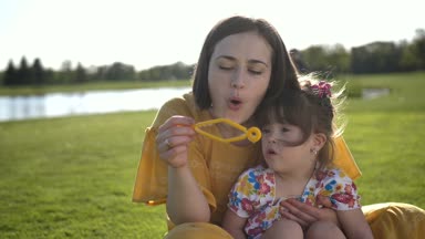 Anne ve özel kızı kabarcıklar parkta üfleme