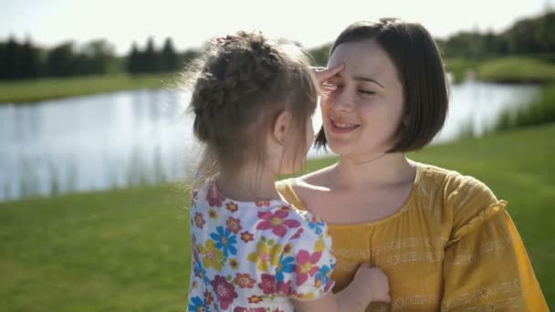 Glad mamma och dotter poserar på kameran i park — Stockvideo