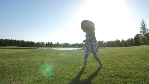 Μικρό παιδί κορίτσι με σύνδρομο down περπάτημα στη χλόη — Αρχείο Βίντεο