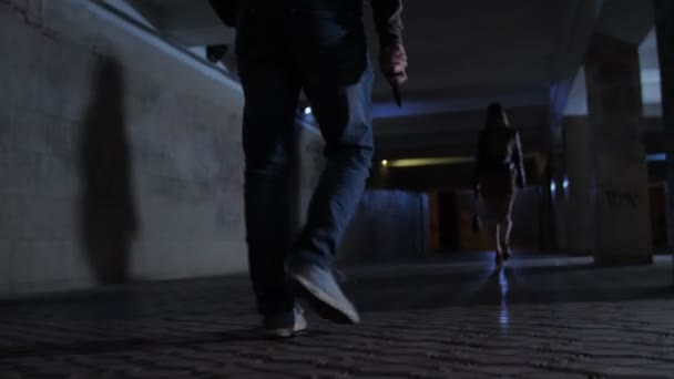 Patas masculinas con cuchillo persiguiendo mujer en túnel — Vídeo de stock