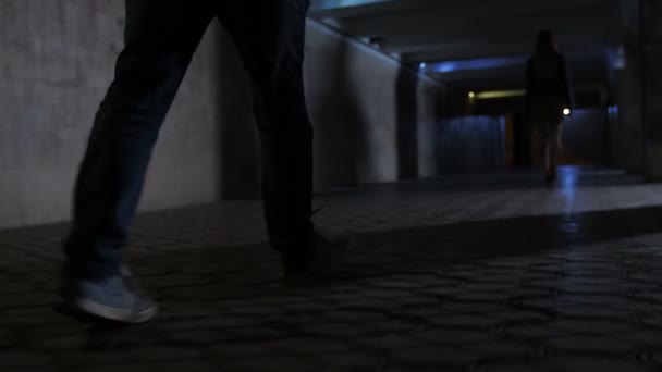 Closeup criminelen benen achter slachtoffer in duisternis — Stockvideo