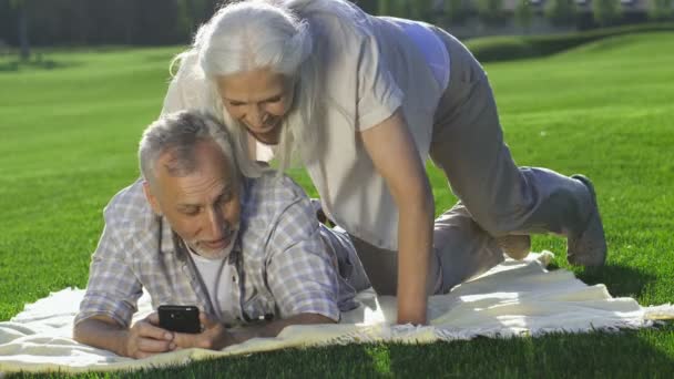 Beauiful starší žena připojí manžel s mobil — Stock video
