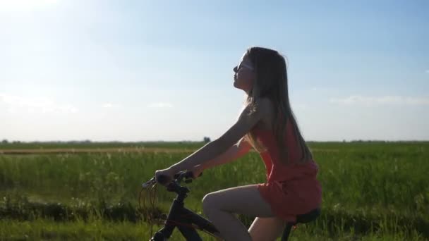 Cute teen girl riding bike in countryside — Stock Video