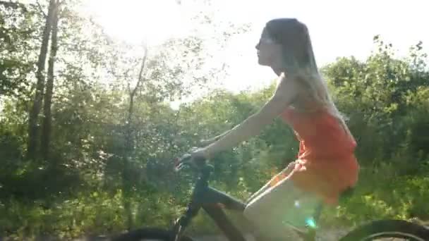Девочка-подросток катается на велосипеде по сельской дороге в сумерках — стоковое видео