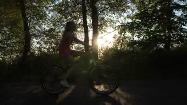 Tiener meisje op fiets genieten van de prachtige zonsondergang — Stockvideo