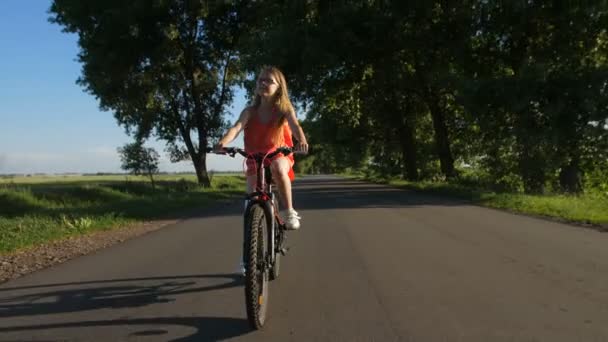Menina adolescente desportiva se divertindo andando de bicicleta — Vídeo de Stock