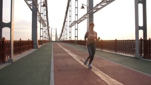 Gorgeous fitness lady running on pedestrian bridge — Stock Video