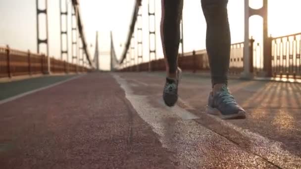 Closeup pés femininos correndo na ponte ao pôr do sol — Vídeo de Stock