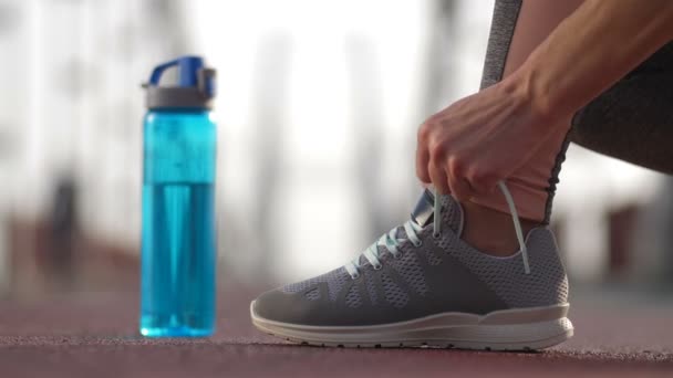 Acercamiento corredores pies en zapatillas de deporte atando cordones — Vídeo de stock