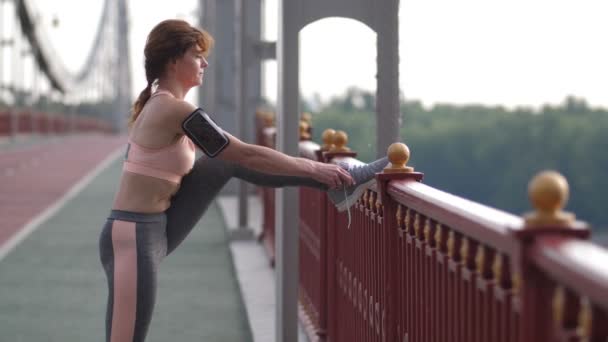 Flexible senior woman tying shoelaces on sneakers — Stock Video