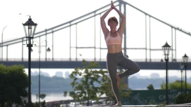 Femme mûre dans l'arbre pose yoga asana en ville — Video