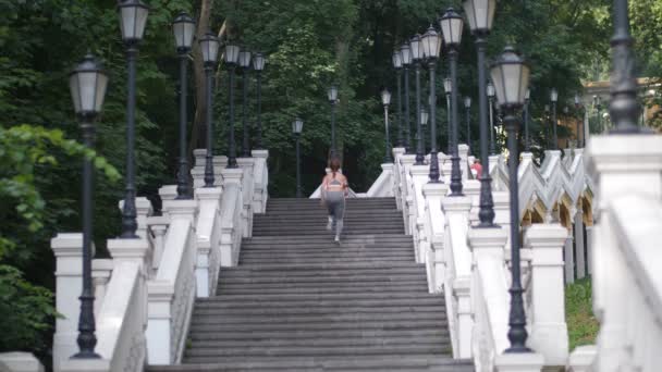 Athletic woman running up the stairs in the park — Stock Video