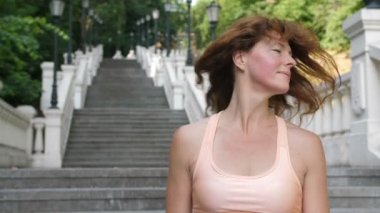 Kızıl saçlı sallayarak ve gülümseyen sportif Olgun kadın