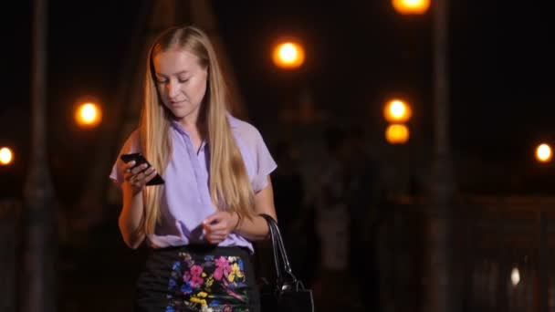 Junge Frau läuft mit Smartphone und lächelt — Stockvideo