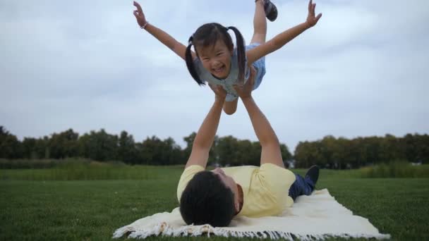 Грайливий батько піднімає милу дочку на відкритому повітрі — стокове відео