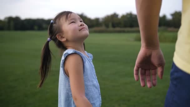 Азиатские отец и дочь держатся за руки и ходят — стоковое видео