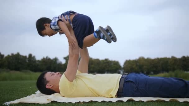 Loving asian father lifting up his laughing boy — Stock Video