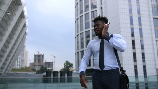 Безтурботний чорний бізнесмен танцює на міській вулиці — стокове відео