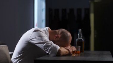 Masanın üzerinde yatan alkol depresif adam