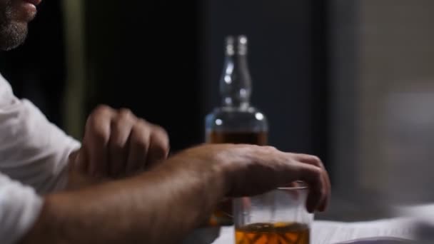 Nadenkend man leunend handen op glas whiskey — Stockvideo