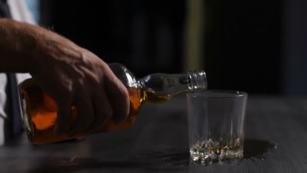 Männliche Hand füllt Glas mit Alkohol auf — Stockvideo