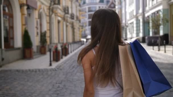 Menina de compras atraente olhando para trás e sorrindo — Vídeo de Stock