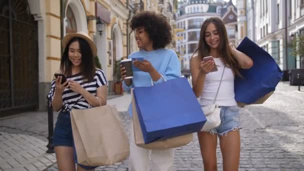 Diverse shopper girls sharing content with phones — Stock Video