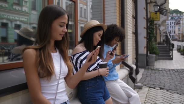 Diverse girls with cellphones networking outdoors — Stock Video