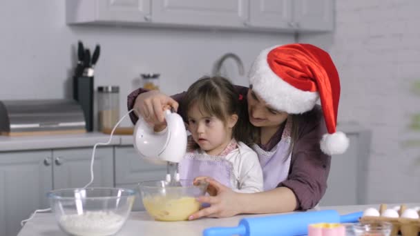 Ребенок с особыми потребностями помогает маме готовить рождественское печенье — стоковое видео