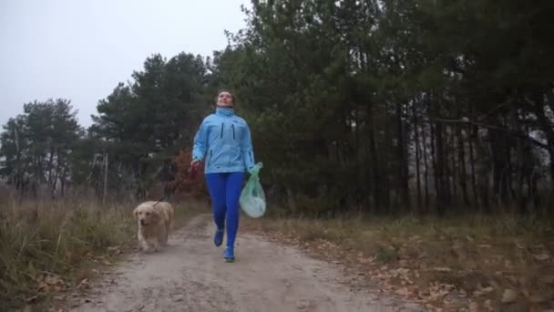 Chica amigable con el medio ambiente con mascotas que trotan al aire libre — Vídeo de stock