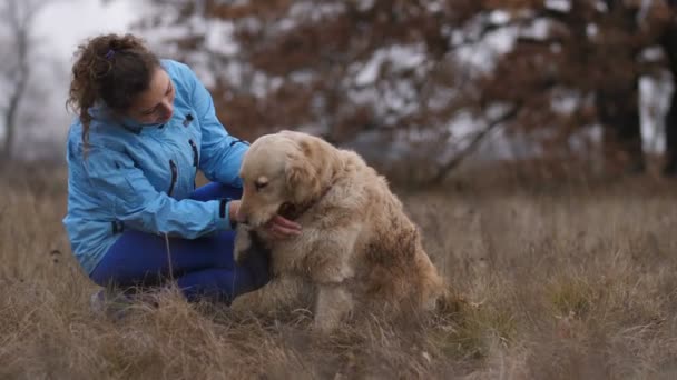 Neşeli kadın onun labrador retriever okşama — Stok video