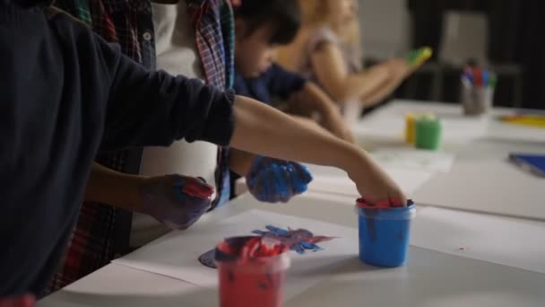 Diversos niños con manos pintadas en clase de arte — Vídeos de Stock