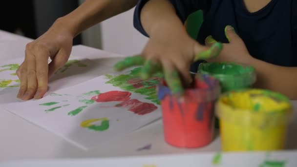 Menina com as mãos em pinturas pintura de dedo na classe — Vídeo de Stock